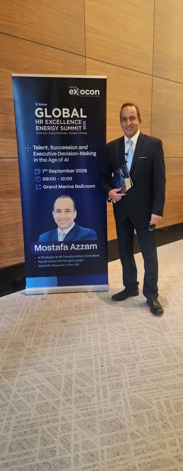 Mostafa Azzam beside the summit banner before his session