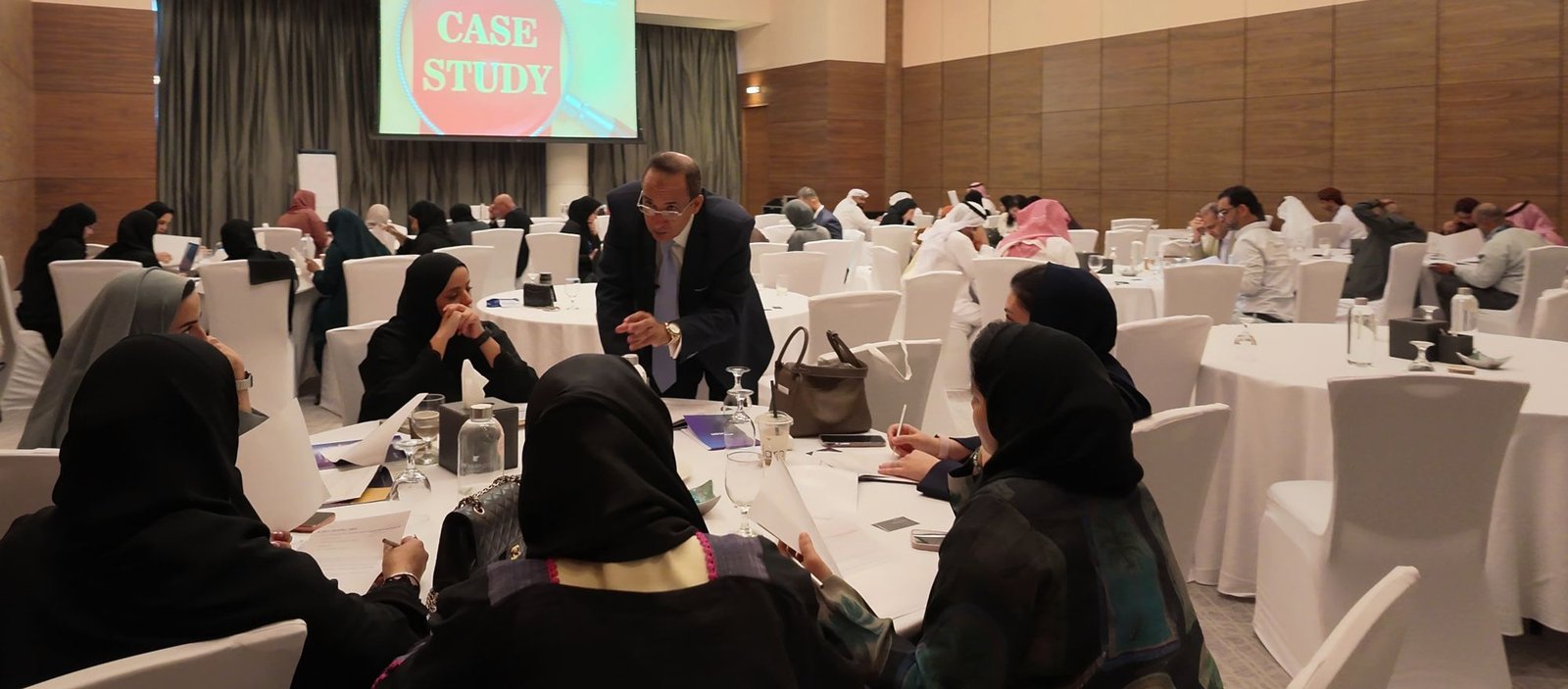 Delegates at round tables working through a case study
