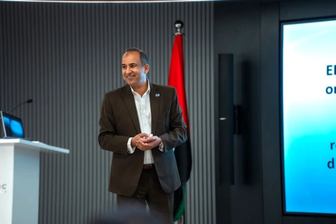 Mostafa Azzam delivering a keynote beside the UAE flag