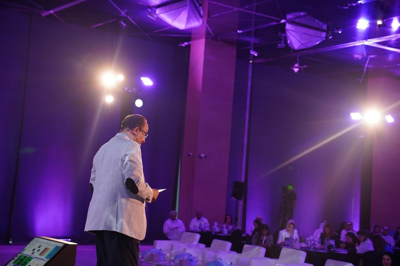 Mostafa Azzam on a stage lit in purple, seen from the audience