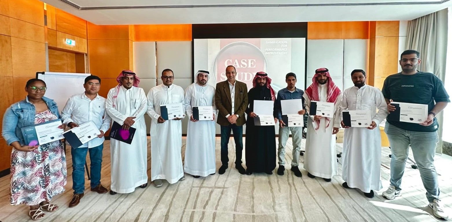Graduates holding their certificates with Mostafa Azzam