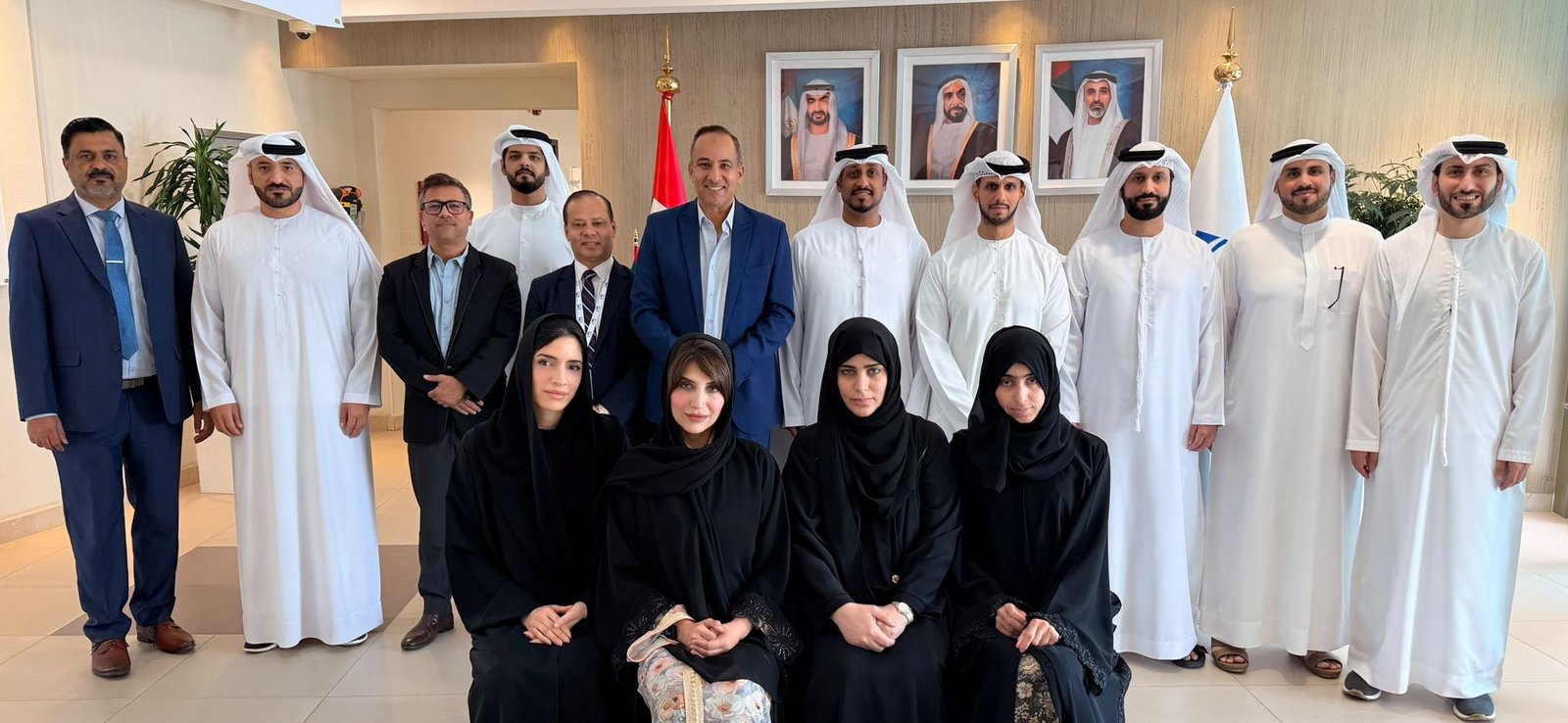Mostafa Azzam with a program cohort and guests beneath the UAE flag, July 2026