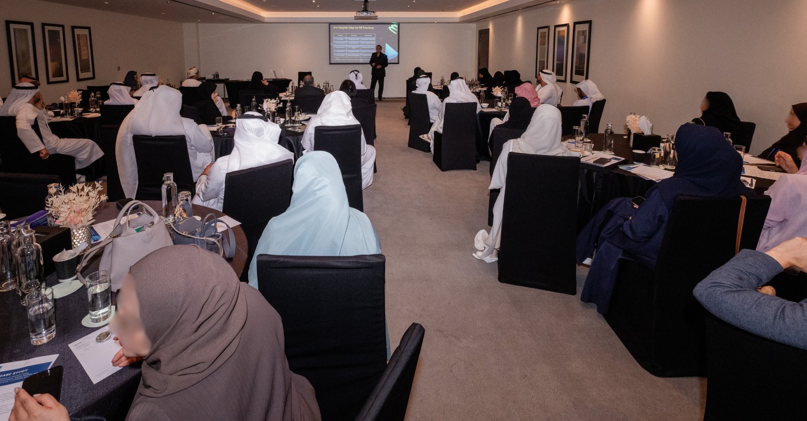 Delegates seated at round tables during a conference workshop