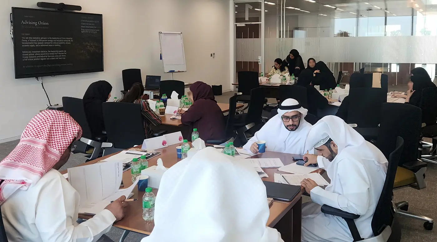 Delegates working in teams around a shared case during a program